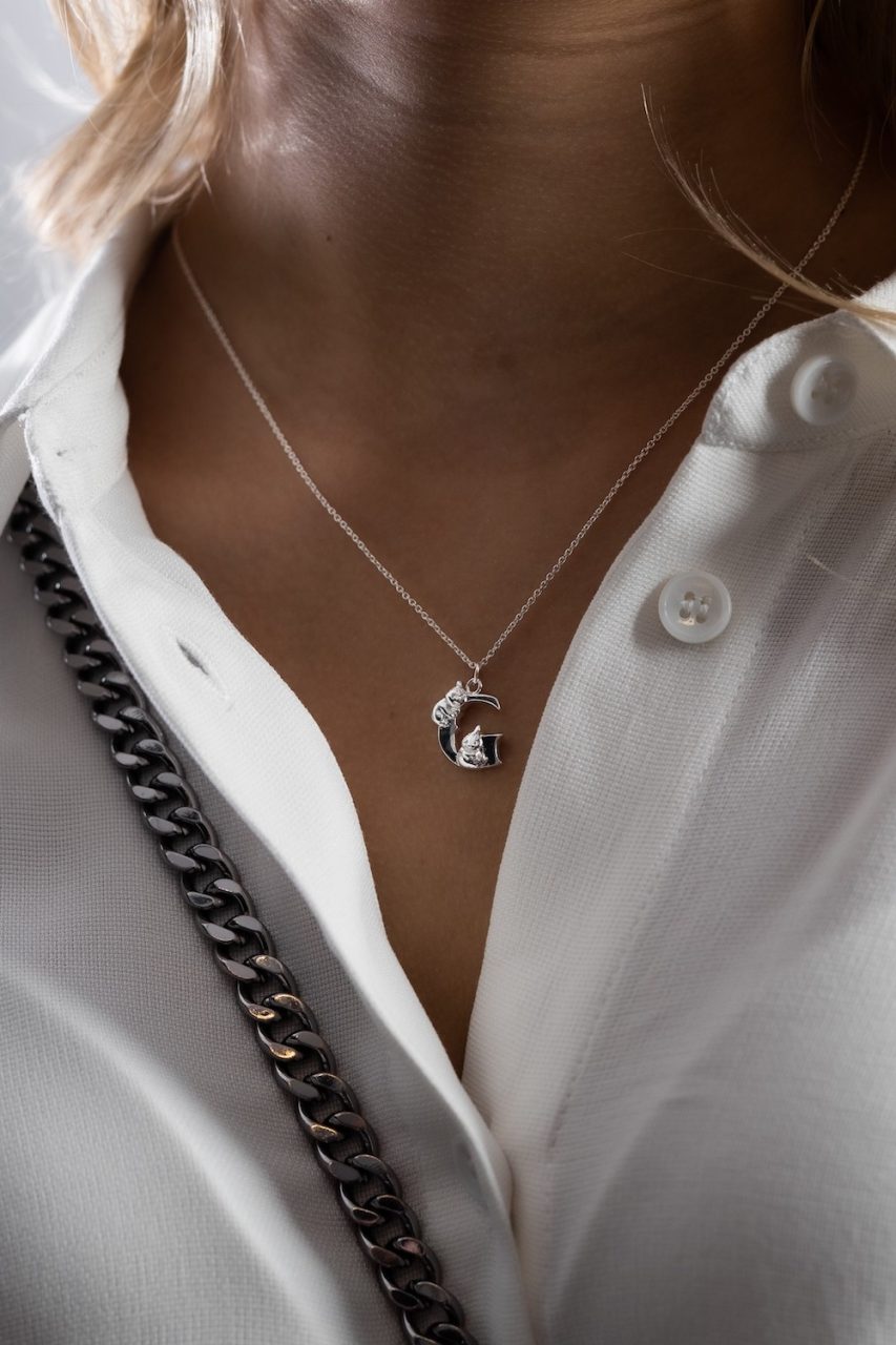 woman wearing letter necklace