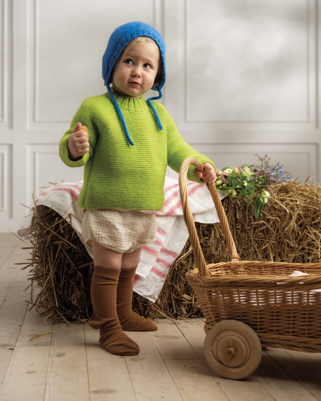 child wearing blue knitted hat and green sweater